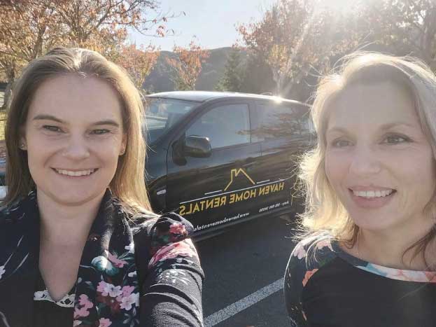 Amy Lett and Lisa White beside the Haven Home Rentals car